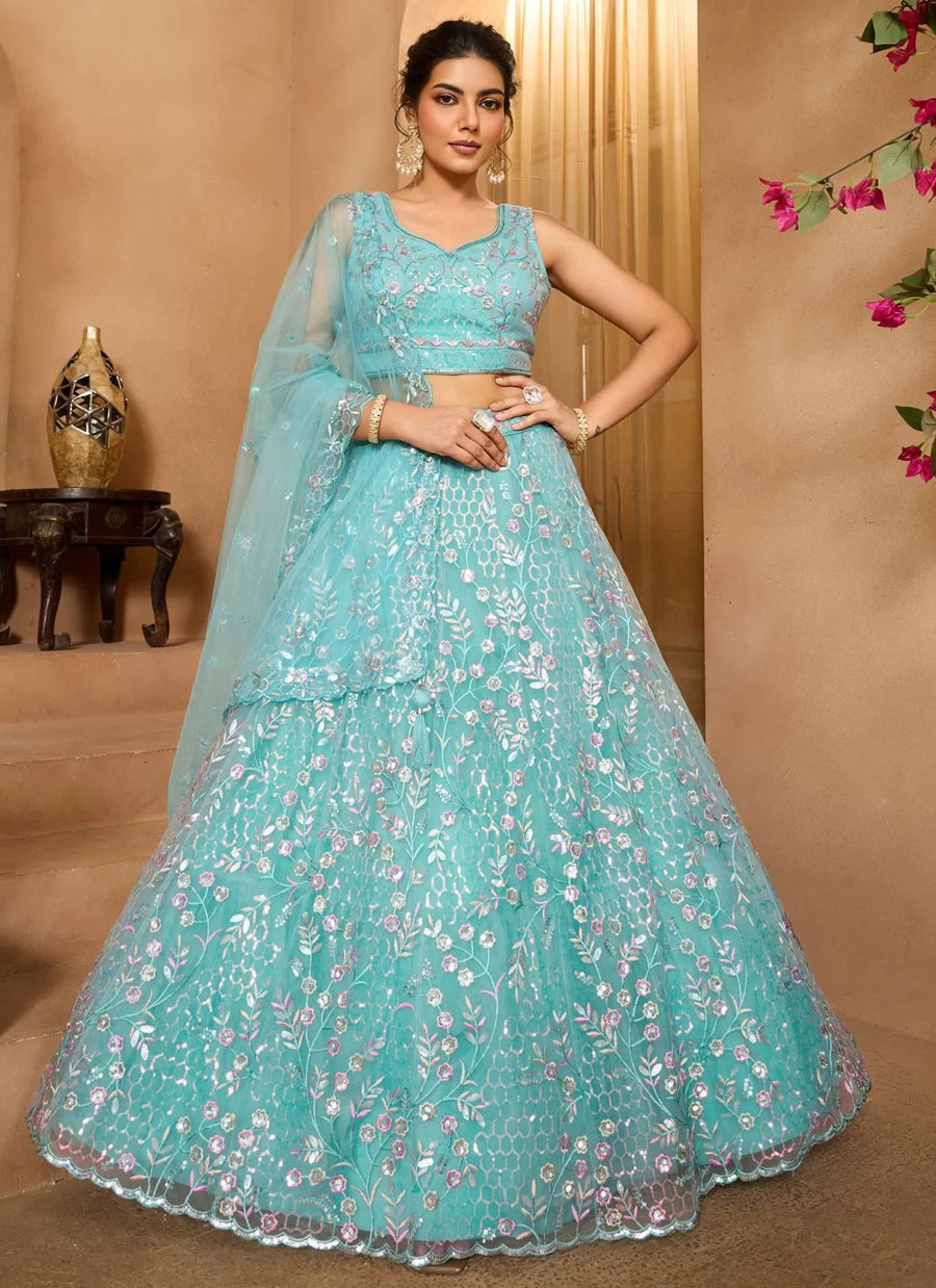 Woman wearing a light blue embroidered lehenga with a beige background
