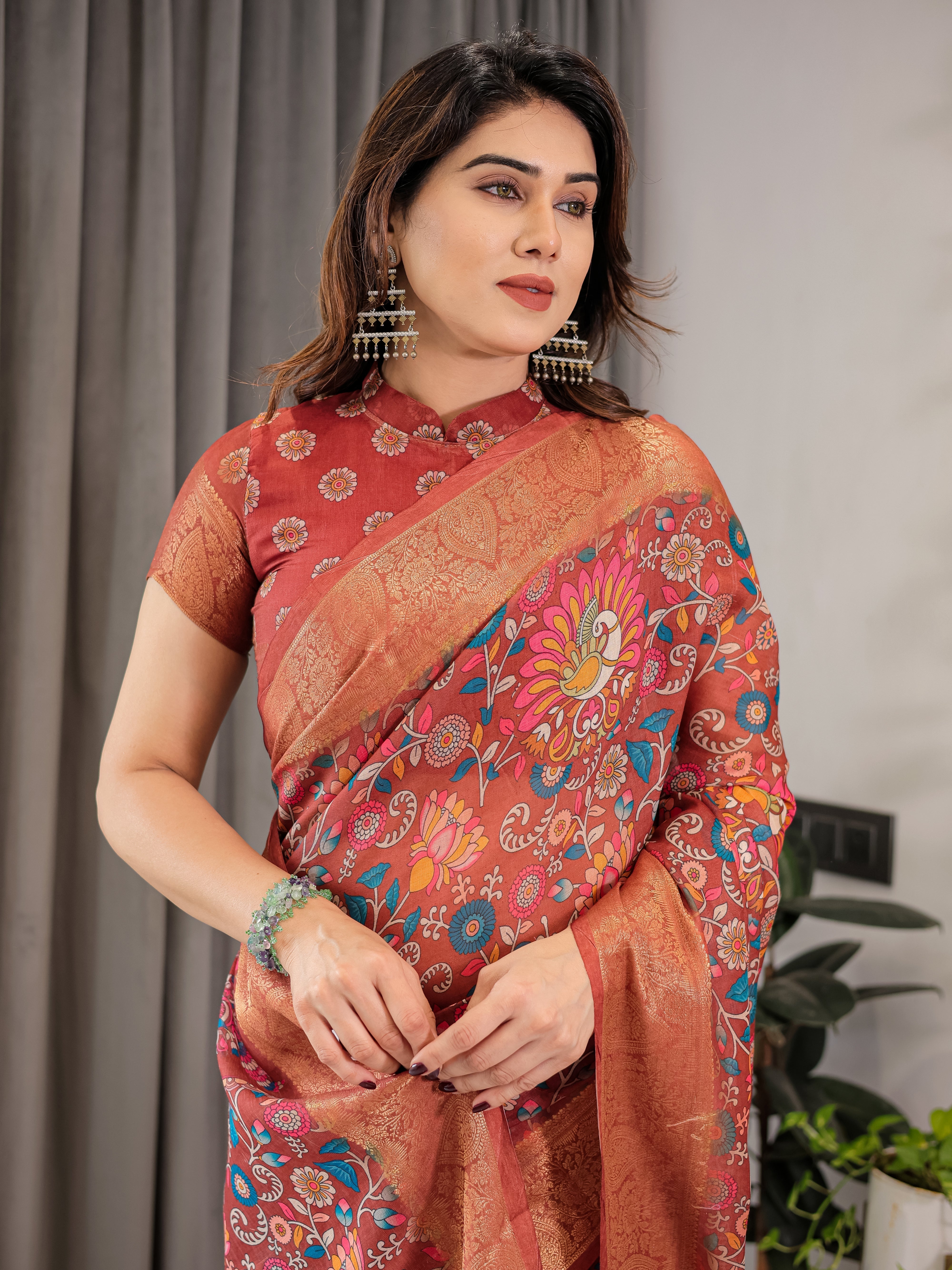 Woman wearing a traditional saree with a floral pattern against a neutral background