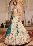 Woman in a traditional outfit with a blue dupatta in an ornate indoor setting