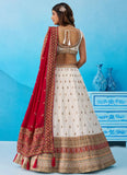White Chinnon Silk semi-stitched lehenga set with embroidered blouse, matching dupatta and designer tassels for wedding wear.